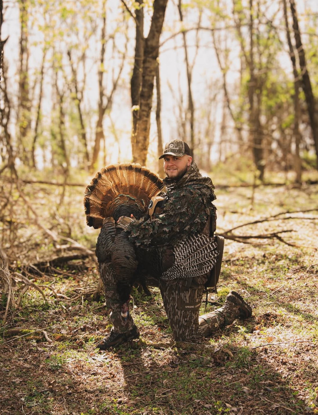 Person holding a turkey in a forest setting