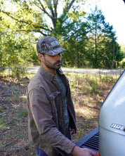 Man standing outdoors with trees in the background turkey hunting