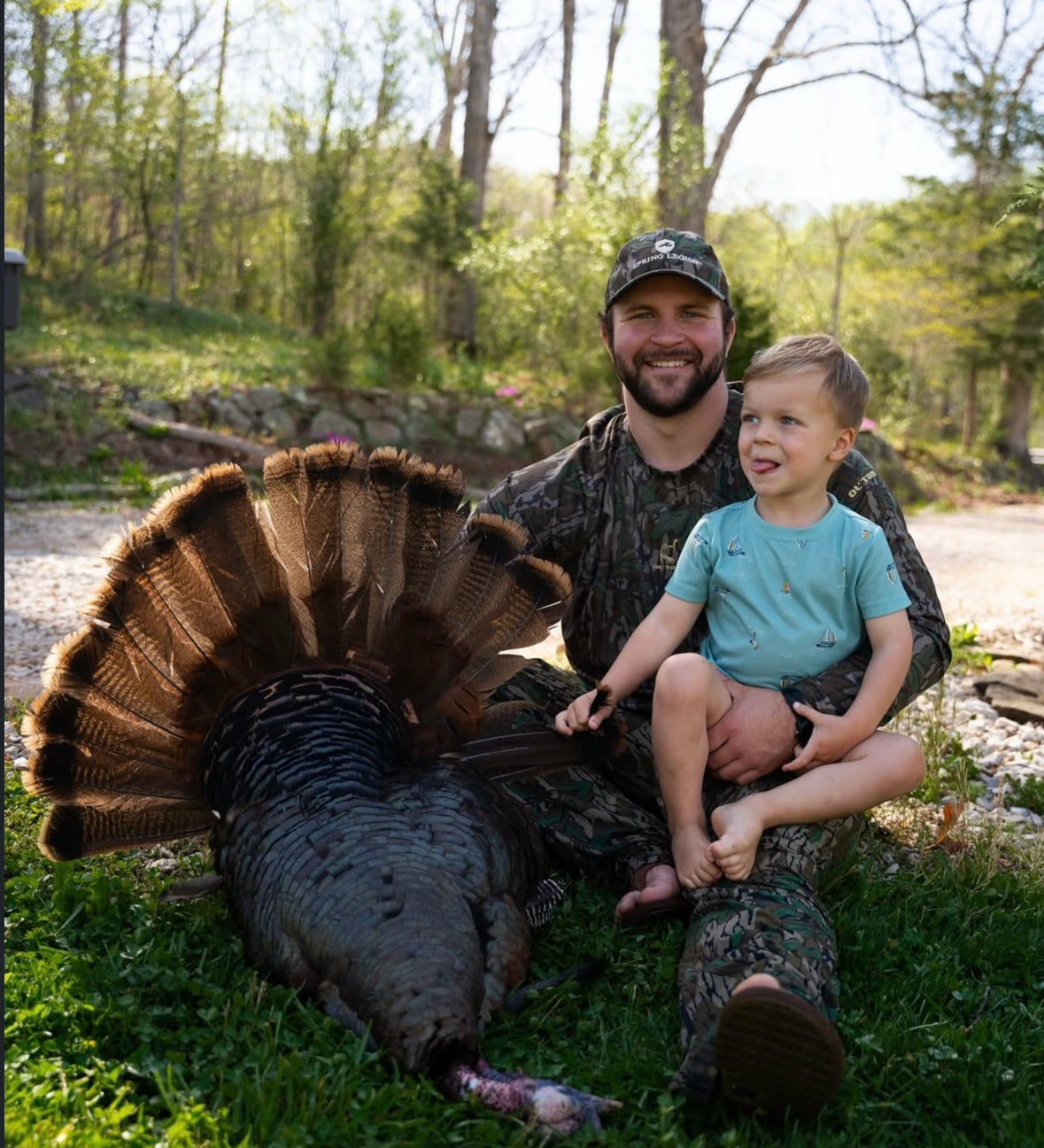 Man and child with a harvested turkey in a natural setting