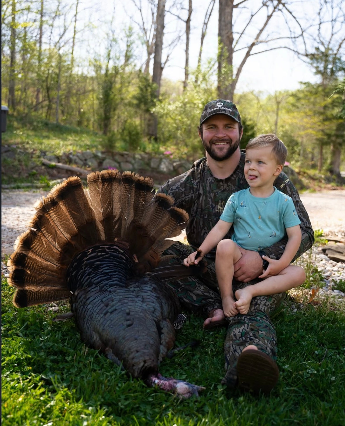 Man and child with a harvested turkey in a natural setting
